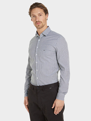 La camicia CALVIN KLEIN BASICA SLIM FIT RIGA è realizzata in cotone organico ed è caratterizzata da una fantasia a righe, mentre il design costituito da un colletto classico, polsini con chiusura a bo... 