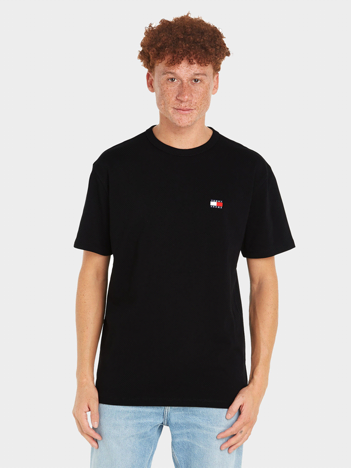 La T-shirt TOMMY JEANS MANICA CORTA BADGE è realizzata in 100% cotone organico e offre una vestibilità regolare con girocollo classico e maniche corte, sfoggiando l