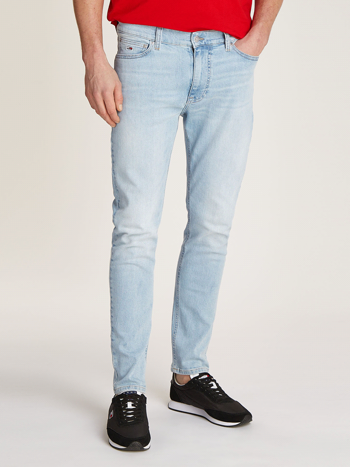 I TOMMY JEANS SIMON skinny fit in denim elasticizzato dal lavaggio chiaro, sono composti da 69% cotone, 30% cotone riciclato, 1% elastan. Con un design classico a 5 tasche, questi jeans presentano sco... 